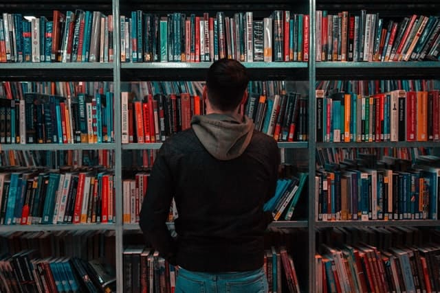 図書室で本を選ぶ男性